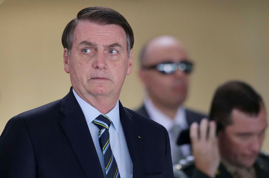 O então presidente da República, Jair Bolsonaro, e seu ajudante de ordens, Mauro Cid, ao fundo no telefone