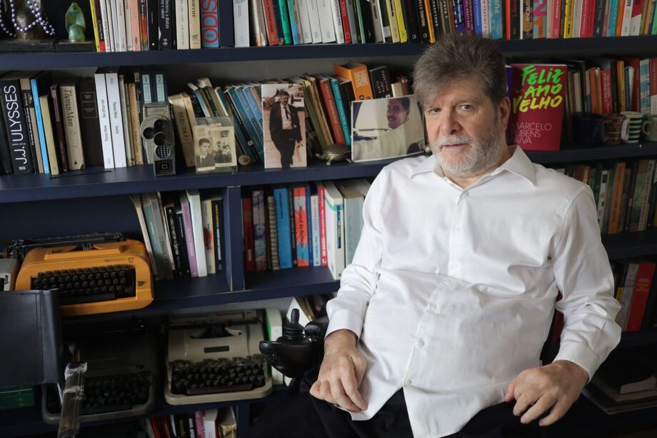 Retrato do escritor Marcelo Rubens Paiva em seu escritório com sua estante de livros.