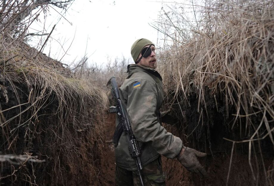 Soldado ucraniano fala com colega em uma trincheira na linha que separa o território dos separatistas pró-Rússia da Ucrânia, em Zolote