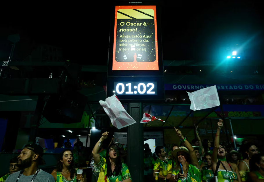 Placa anuncia o filme brasileiro 'Ainda Estou Aqui' como vencedor do Oscar de Melhor Filme Internacional no Sambódromo da Marquês de Sapucaí, no Rio de Janeiro.