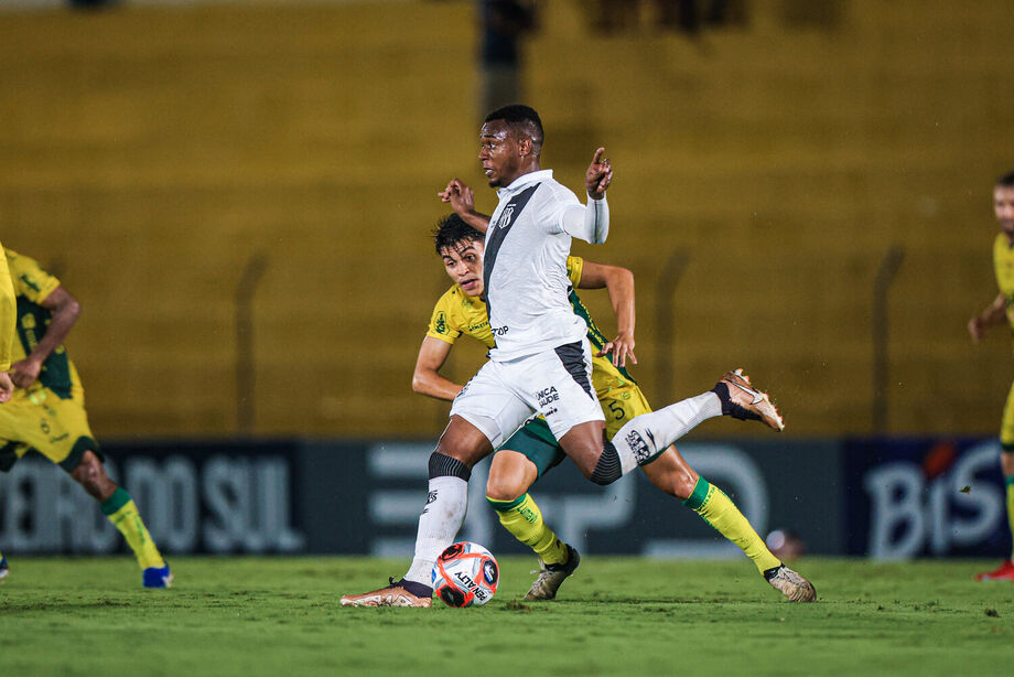 Volante da Ponte Preta conduz a bola durante partida contra equipe de uniforme amarelo. Clube segue reforçando elenco para a disputa da Série C do Campeonato Brasileiro.