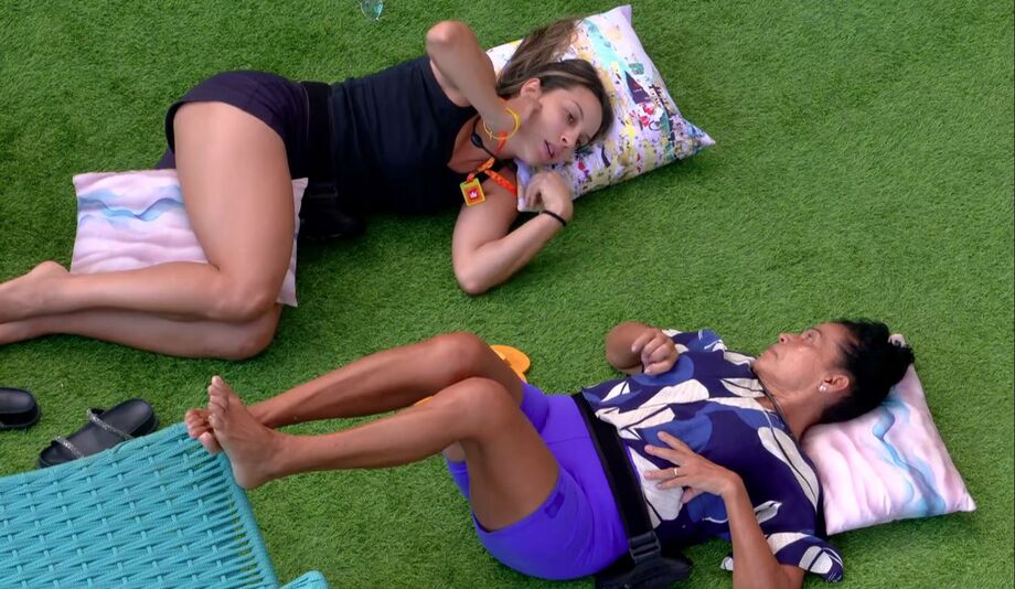 Renata e Vilma conversam deitadas na grama da área externa do BBB 25.