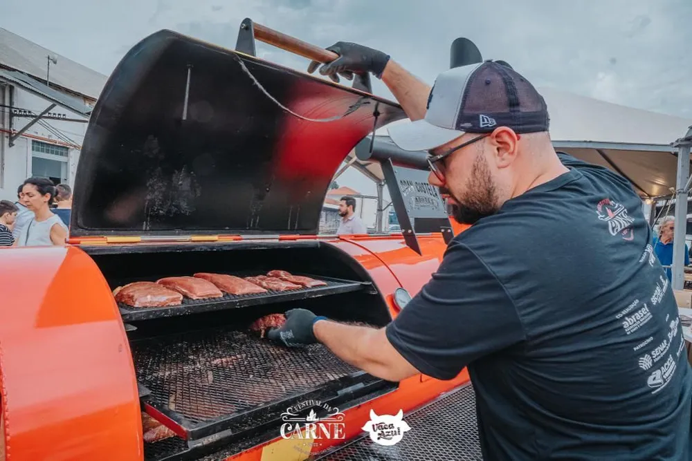 Assador prepara cortes especiais em churrasqueira defumadora durante o Festival Internacional da Carne, em Campo Grande.
