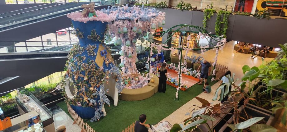 Cenário encantado toma conta da loja Comper, com coelhos gigantes e árvores floridas que fazem brilhar os olhos das crianças.