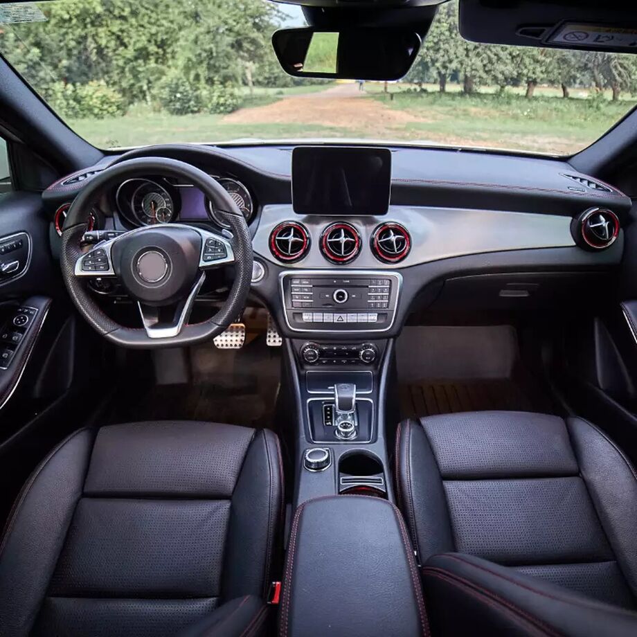 Interior do carro mostra painel completo, bancos em couro e acabamento esportivo, valorizando o conforto e a tecnologia do modelo.