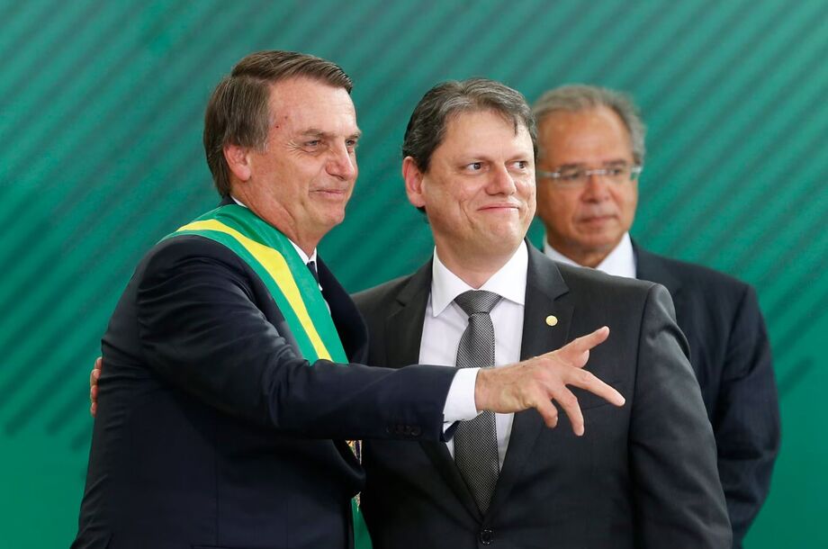 Jair Bolsonaro, ao lado do então ministro da Infraestrutura, Tarcísio Freitas. Ao fundo, Paulo Guedes, que foi ministro da Economia