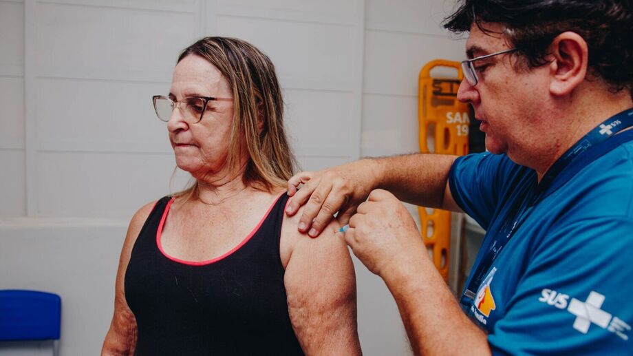 Profissional de saúde aplica dose da vacina contra a gripe em unidade de Campo Grande. MS é destaque nacional ao liberar imunização para toda a população.