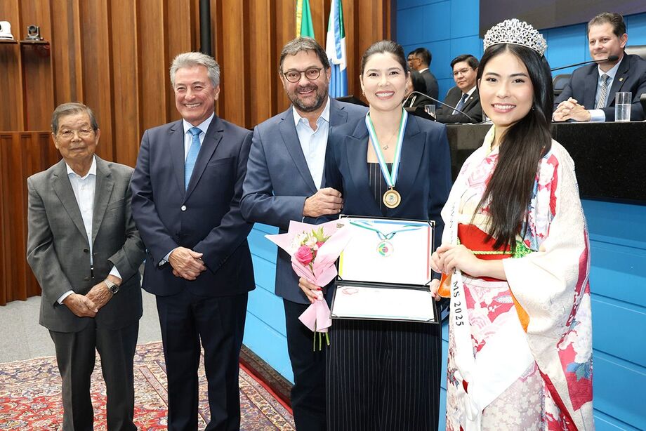 Na sequência (esq. para dir.): Suji Sato (pai de Adriana), deputado Roberto Hashioka, Sérgio Longen (marido de Adriana), a médica Adriana Sato (homenageada) e a Miss Nikkey 2025, Mariáh Silva Arakaki Mizuno Prado