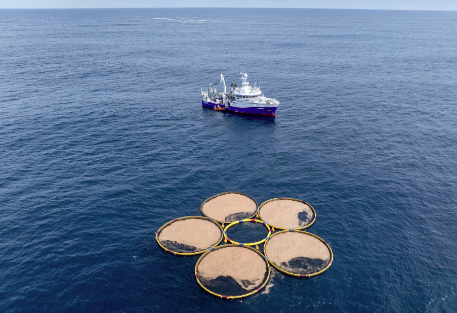 Estruturas circulares flutuam perto de um navio de pesquisa no Oceano Pacífico, na Nova Zelândia. Projeto cultiva organismos minúsculos chamados fitoplâncton, que absorvem dióxido de carbono do oceano.