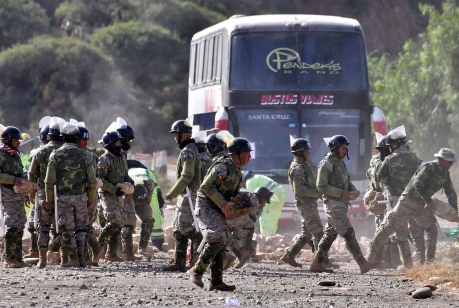 Polícia militar despeja carreta que estava bloqueada por partidas do ex-presidente da Bolívia, Evo Morales.
