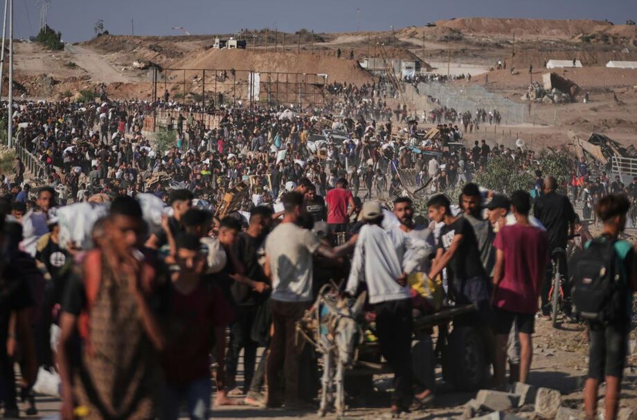 Imagem desta quinta-feira, 26, mostra palestinos próximos a centro de distribuição de alimentos em Khan Younis, sul da Faixa de Gaza. Principal passagem no norte foi fechada por dois dias, anunciou governo de Israel