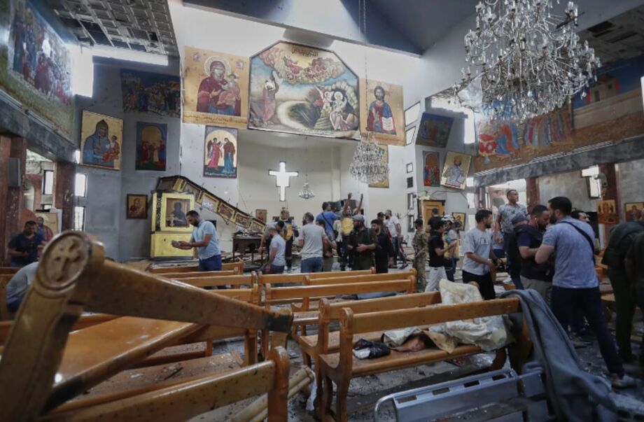 Cidadãos sírios e forças de segurança inspecionam os danos dentro da igreja Mar Elias.