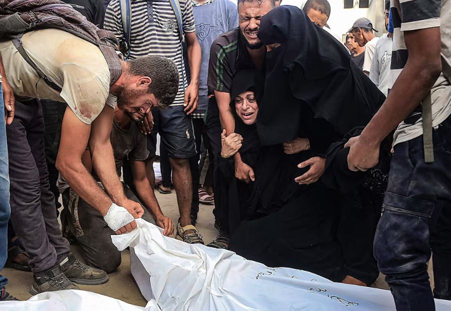 Palestinos lamentam uma das vítimas mortas em um ponto de distribuição de comida na
