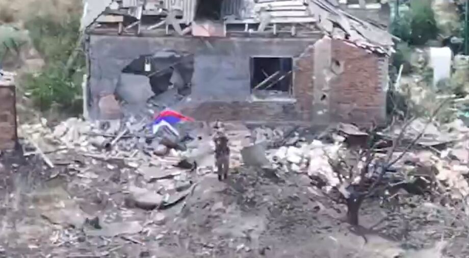Imagem de drones do Ministério da Defesa russo mostra soldado hasteando bandeira nacional na cidade de Chasiv Yar, no leste da Ucrânia.