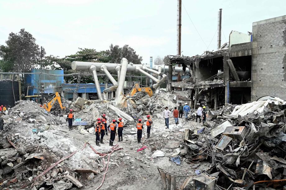 Equipes de resgate inspecionam os destroços da unidade farmacêutica destruída da Sigachi Industries, um dia após explosão.