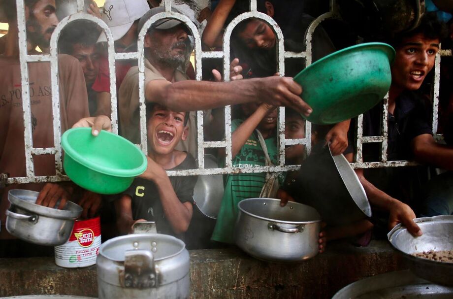 Palestinos tentam receber comida em uma zona humanitária na cidade de Khan Yunis, no sul da Faixa de Gaza