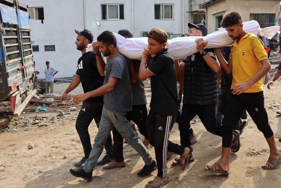Palestinos carregam corpo de pessoa morta enquanto procurava ajuda perto de Zikim, no norte da Faixa de Gaza.
