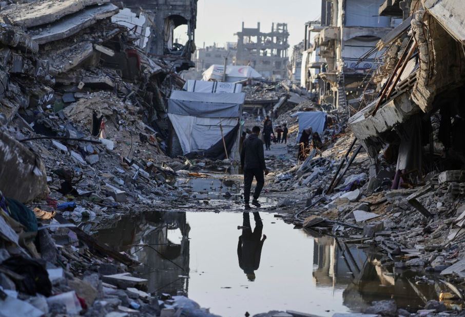 Palestinos caminham entre os escombros em Gaza