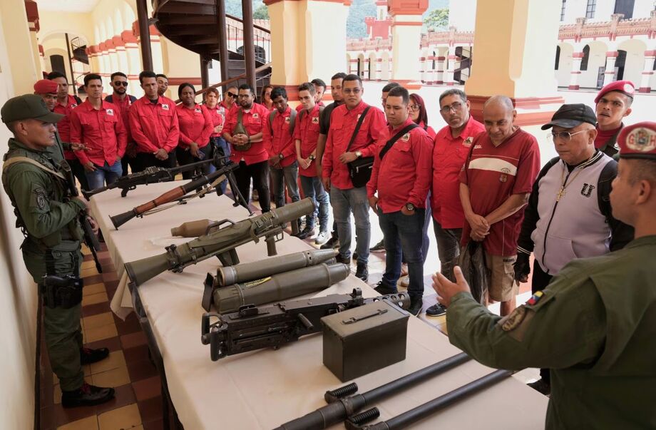 Um membro da guarda presidencial venezuelana mostra armas aos que se alistaram para integrar as milícias civis durante uma campanha nacional de recrutamento convocada pelo ditador Nicolás Maduro, no Museu Militar de Caracas, Venezuela.