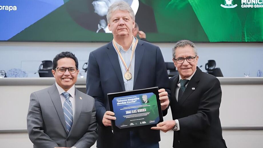 O secretário estadual Jaime Verruck recebe a Medalha Legislativa Afonso Nogueira Simões Corrêa durante sessão solene pelos 50 anos da Embrapa Gado de Corte, na Câmara Municipal de Campo Grande; entrega foi feita pelo presidente da Casa, vereador Papy, a