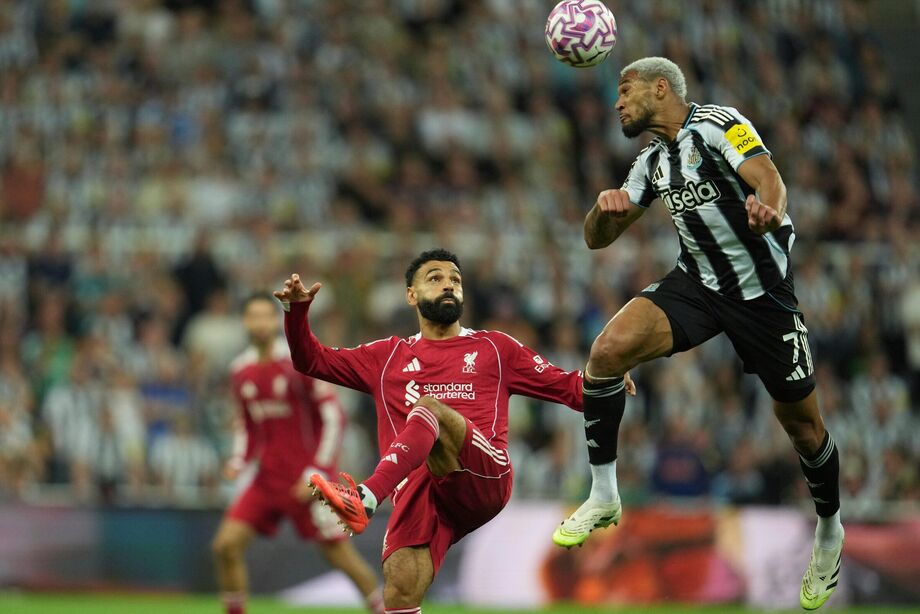 Joelinton ganha dividida pelo alto com Mohamed Salah durante jogo entre Newcastle e Liverpool na Premier League.