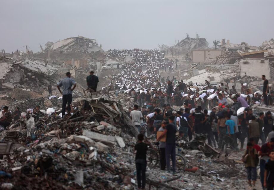 Palestinos trazem de volta pacotes de ajuda que conseguiram pegar enquanto voltam de Beit Lahia, em 29 de julho de 2025, depois que caminhões de ajuda entraram na Faixa de Gaza