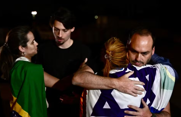 Carlos Bolsonaro (à direita) e Jair Renan Bolsonaro cumprimentam apoiadores do pai durante vigília.