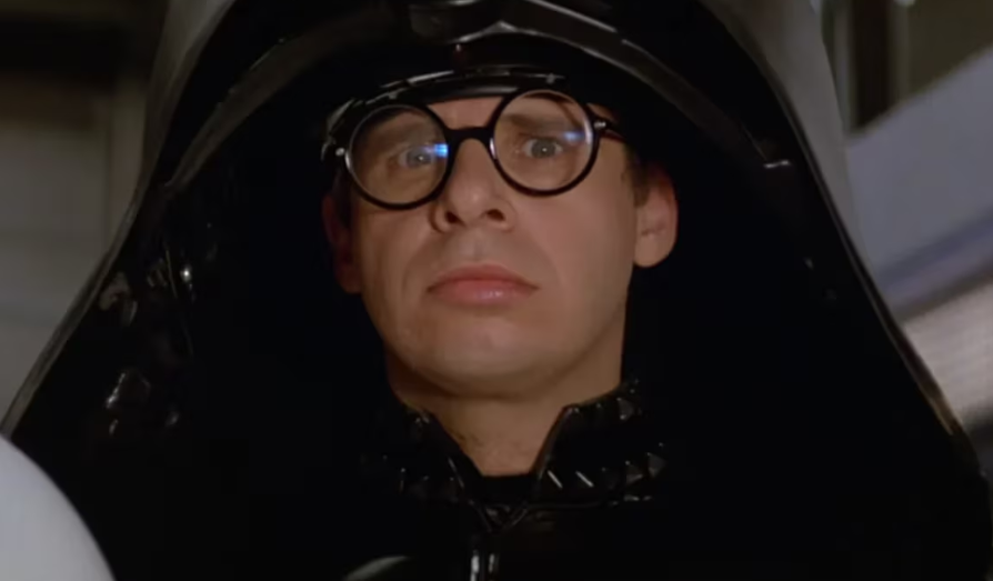 Rick Moranis como Dark Helmet em 'S.O.S. - Tem um Louco Solto no Espaço'; ator voltará ao papel em sequência, marcada para 2027