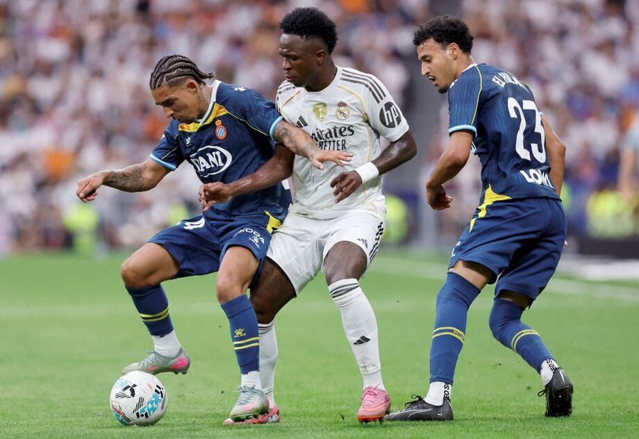 O atacante brasileiro Vinicius Junior, do Real Madrid, disputa a bola com o inglês Tyrhys Dolan, do Espanyol, e o marroquino Omar El Hilali, durante partida do Campeonato Espanhol.