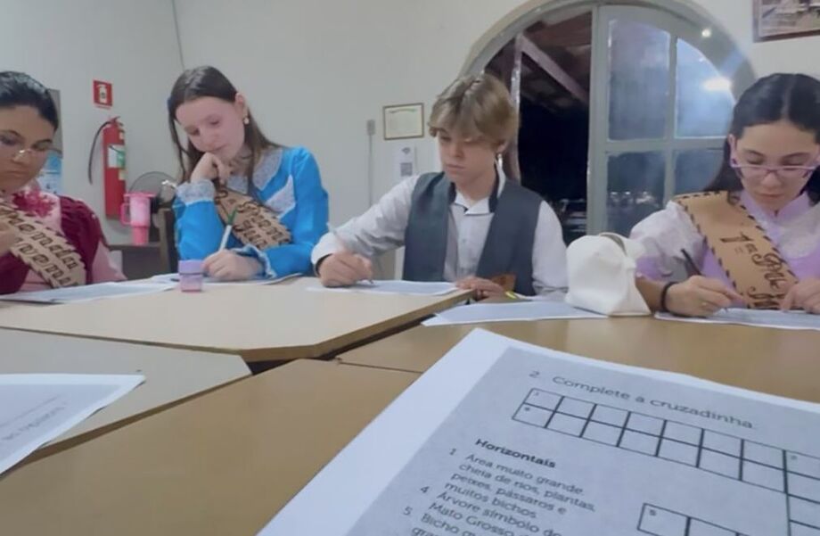 Participantes da oficina cultural em Dourados, interagindo com o novo livro da ALEMS e aprendendo sobre o folclore regional.