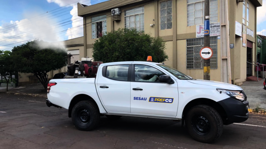 Equipe aplica fumacê contra mosquitos adultos na rua de bairro de Campo Grande