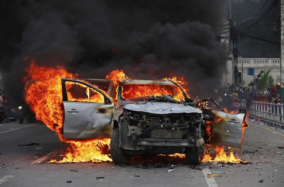 Um carro pega fogo em frente ao Singha Durbar, o principal prédio administrativo do governo do Nepal, em Katmandu, em 9 de setembro de 2025