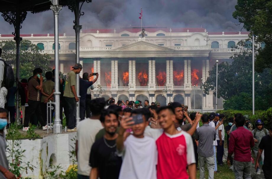 Manifestantes tiram selfies e comemoram no Singha Durbar, sede de vários ministérios e escritórios do governo do Nepal, após o local ter sido incendiado