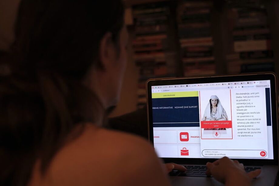 Uma mulher olha para um computador enquanto usa o portal do governo albanês E - Albânia, agora auxiliado pelo avatar do ministro do gabinete de inteligência artificial do governo Diella, em Tirana