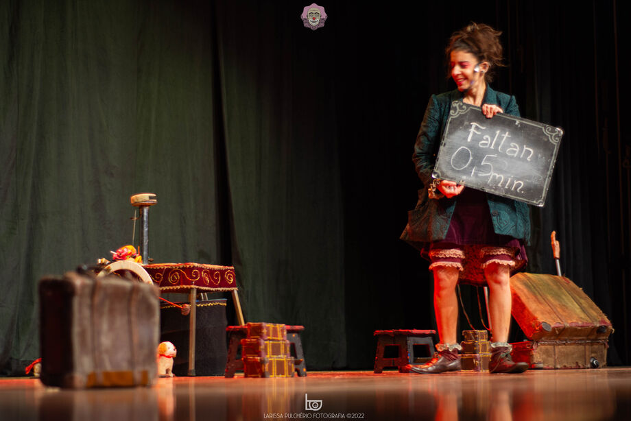 Cena de espetáculo na Mostra Pantalhaç@s, com palhaça anunciando o início da apresentação.