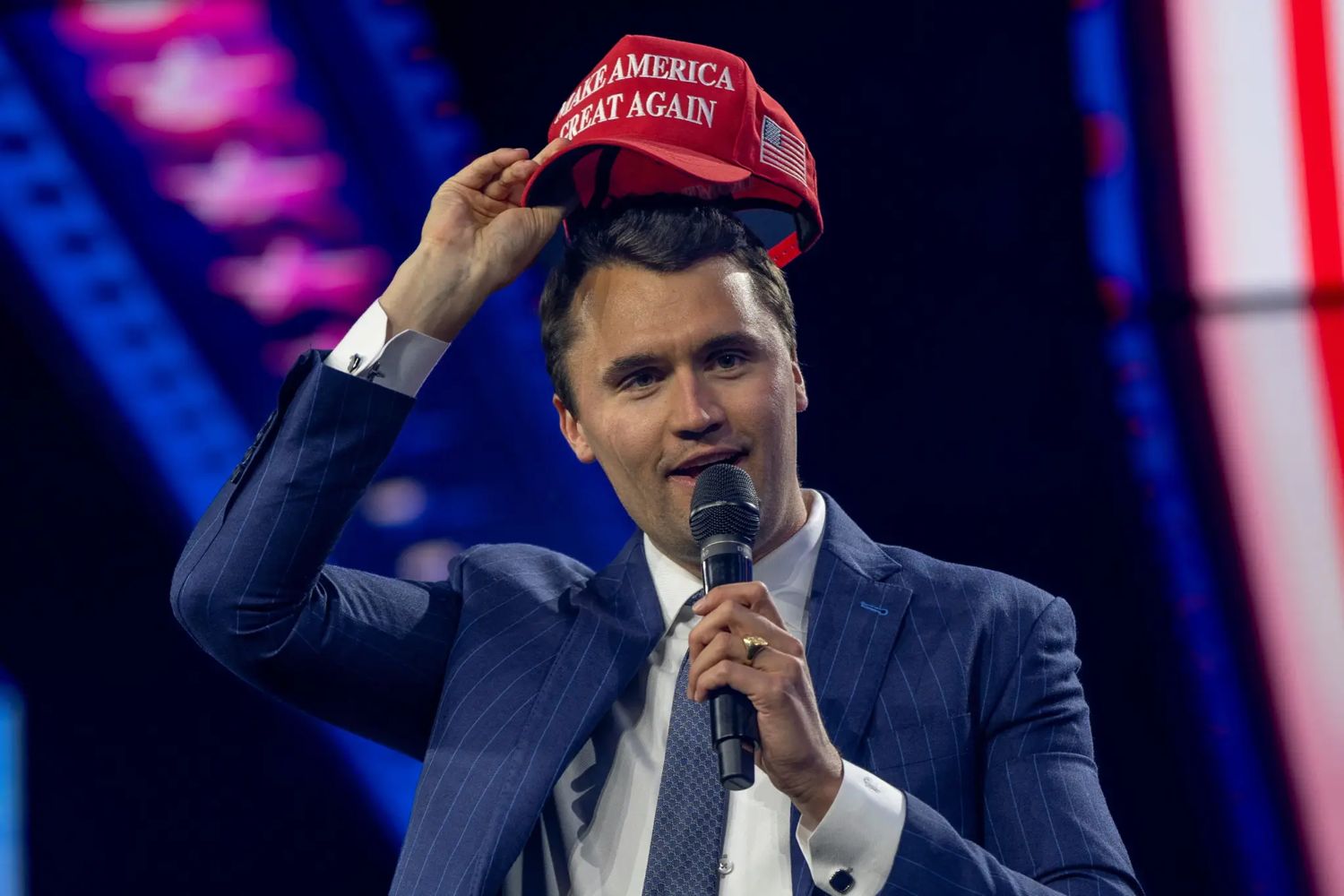 Charlie Kirk, fundador da Turning Point USA, coloca um boné MAGA durante a conferência AmericaFest 2024, patrocinada pelo grupo conservador Turning Point, em Phoenix, Arizona, EUA, em 19 de dezembro de 2024.
