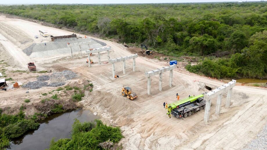 Máquinas e operários atuam na preparação do solo e na construção dos pilares da superestrutura da ponte