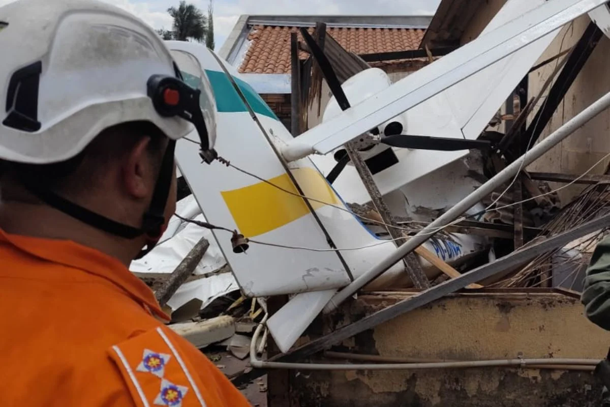 Avião de pequeno porte cai sobre casa em Goiânia; piloto sobrevive e área é isolada por risco de explosão.