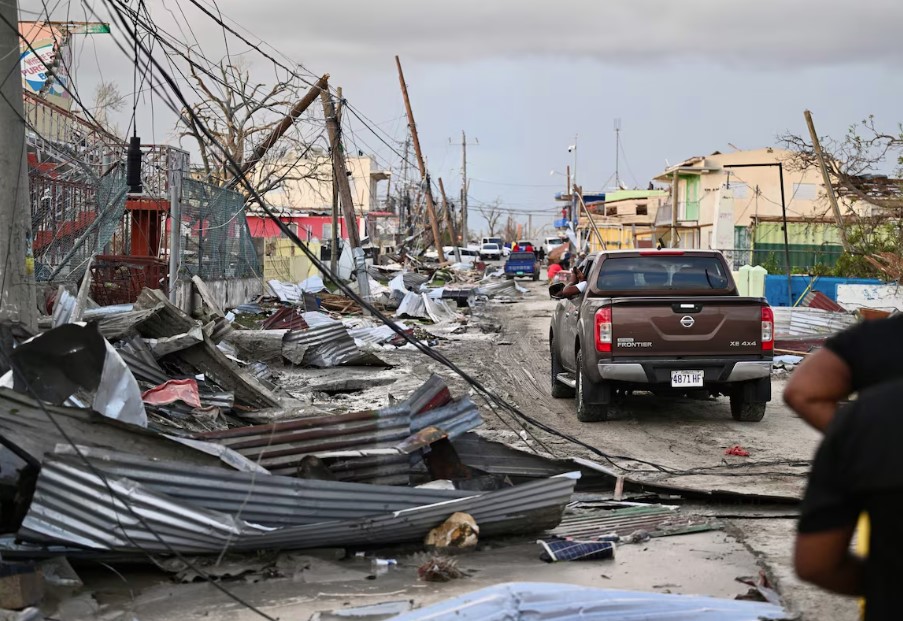 Carro passa por um bairro destruído após a passagem do Furacão Melissa, em Black River, na Jamaica.