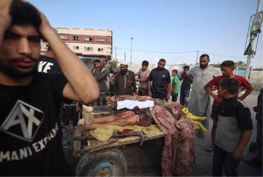 Palestinos reagem ao lado dos corpos de pessoas em outro ataque nesta sexta (26)