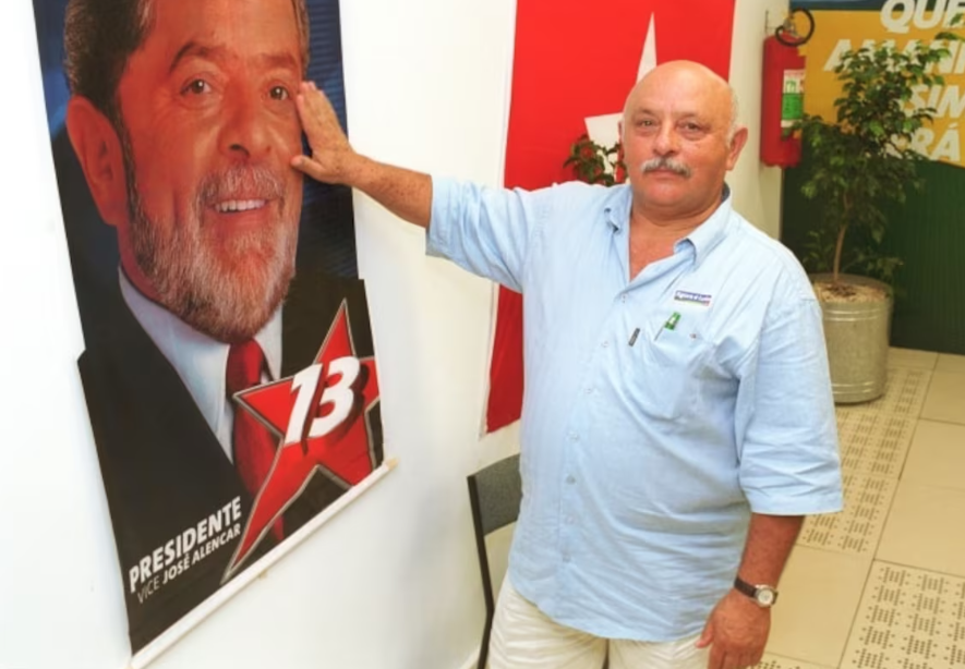 O irmão do ex-presidente Lula, Frei Chico, posa com um cartaz da campanha presidencial do petista de 2002.