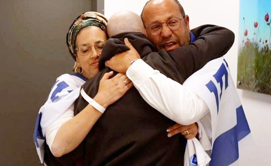 Familiares abraçam o ex-refém Eitan Mor, em uma base militar israelense perto da Faixa de Gaza