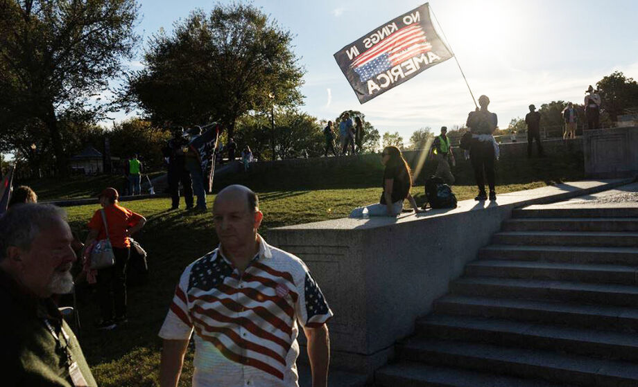 Um manifestante agita uma bandeira durante um comício no Lincoln Memorial em 17 de outubro de 2025, em Washington, DC. O comício foi organizado pela organização sem fins lucrativos Indivisible, antes do protesto 'No Kings' em Washington, em 18 de outubro.