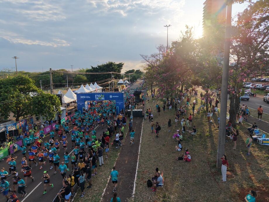 Vista aérea mostra a multidão de atletas tomando conta da Avenida Afonso Pena, transformada em pista de corrida e superação.