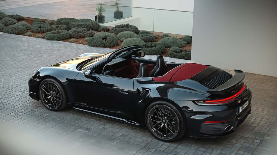 A versão Cabriolet do novo Porsche 911 Turbo S híbrido 2026 traz capota retrátil e acabamento interno em vermelho marcante.