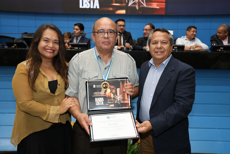 O radialista Marcelo Ortiz recebe a Comenda Antônio Tonanni durante sessão solene na Assembleia Legislativa de Mato Grosso do Sul, ao lado de Jaqueline Lopes e Oscar Martinez, representantes do deputado Pedro Kemp