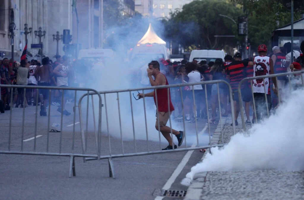 Bombas de fumaça marcam confronto entre torcedores do Flamengo e polícia durante desfile.