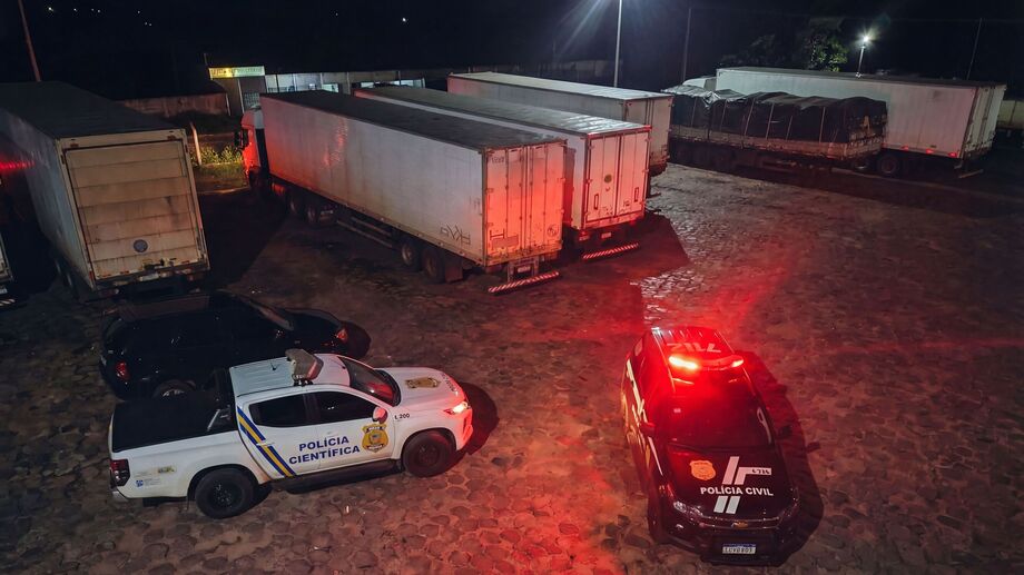 Viaturas da Polícia Civil e da Polícia Científica cercam carretas estacionadas no pátio do Posto Caravágio, na BR-163, em Campo Grande, durante atendimento à ocorrência que resultou na localização do corpo de um caminhoneiro.