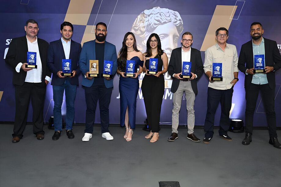No palco do Prêmio MS Industrial de Jornalismo 2025, profissionais premiados posam com os troféus durante a cerimônia realizada na Casa da Indústria, em Campo Grande
