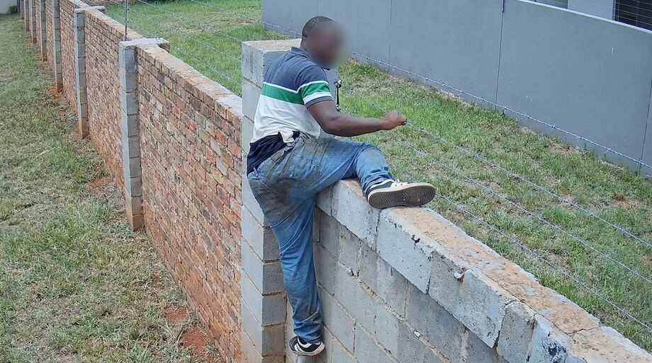 Imagem registrada por câmera de segurança mostra o momento em que o suspeito tenta invadir um condomínio pela cerca.